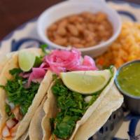 Tacos De La Calle · Hand Made Corn tortillas filled with pork carnitas or asada, cilantro, pickled red onions an...
