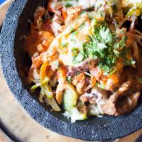 Molcajete · Steak and chicken fajita strips, bell peppers, onions and chorizo all covered with Jack chee...