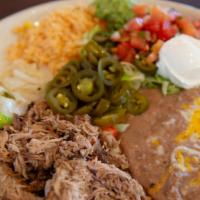 Carnitas Michocan · Pork shoulder slowly braised in Mexican coke and spices. Served with guacamole, sour cream, ...
