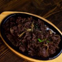 Beef Bulgogi (불고기) · Marinated beef cooked with onions and green onions. Comes with rice and side dishes.