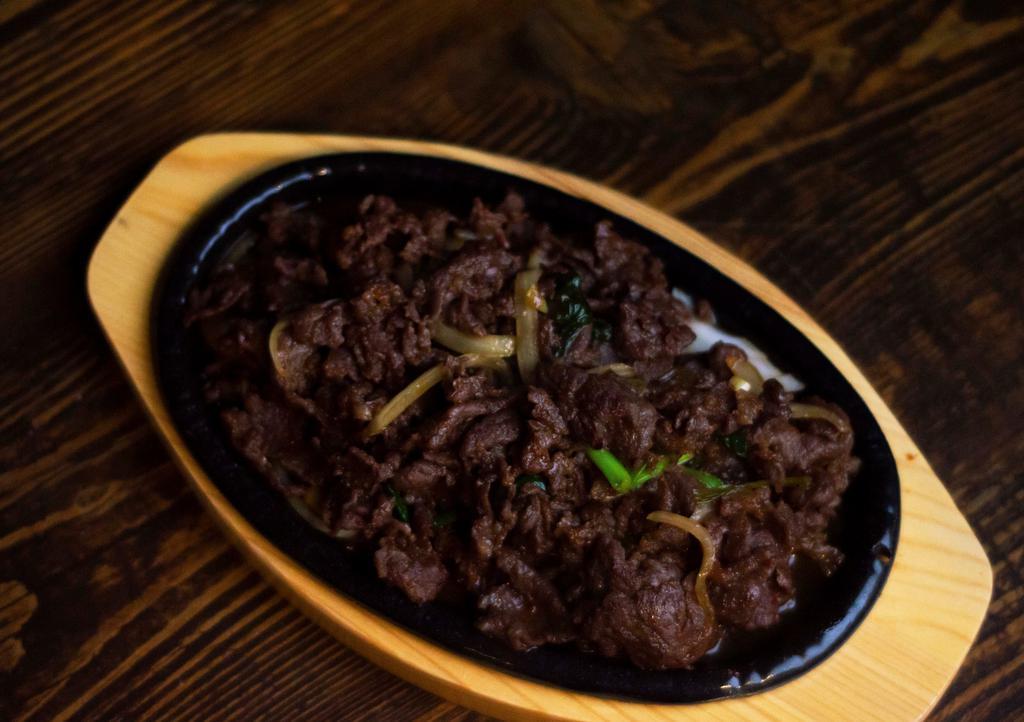 Beef Bulgogi (불고기) · Marinated beef cooked with onions and green onions. Comes with rice and side dishes.