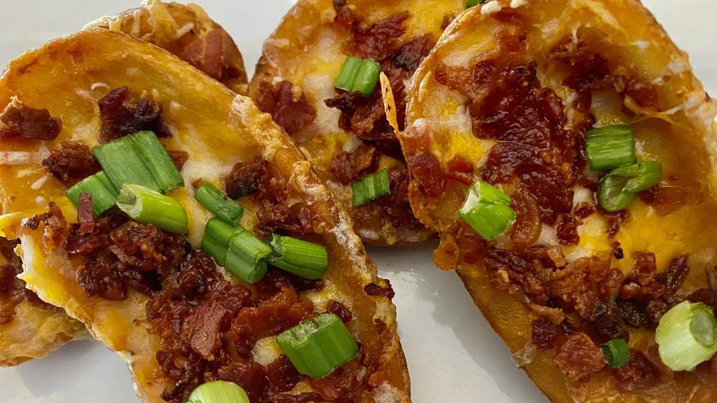 Slate Skins · Potato skins topped with cheese bacon and green onion, served with sour cream.