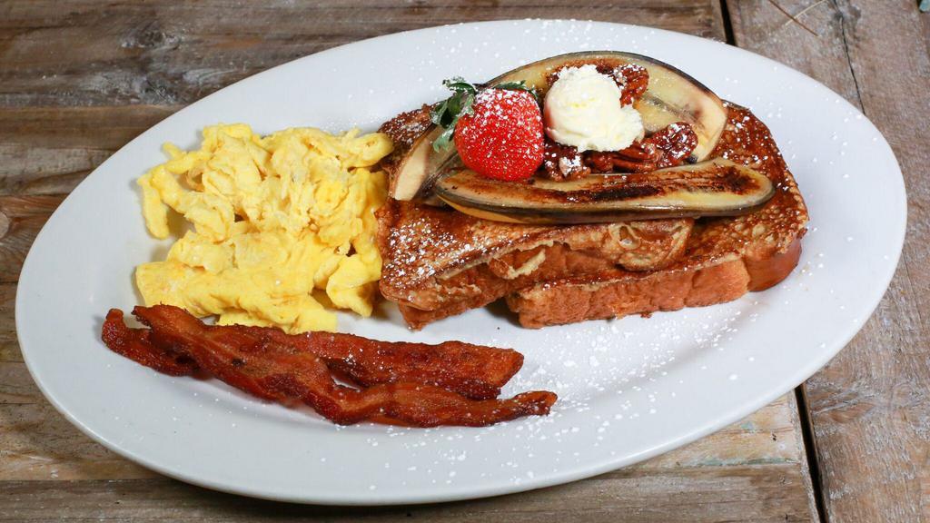 French Toast Tractor Driver Combo · Dipped in our banana cinnamon cream with candied pecans, grilled banana.  Served with two eggs with choice of bacon, sausage links, turkey sausage patties or potatoes.  Served with butter and syrup.