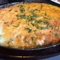 Queso Fundido · A blend of our favorite melted cheeses with stir-fried pico de gallo. Mixed with chorizo, gr...