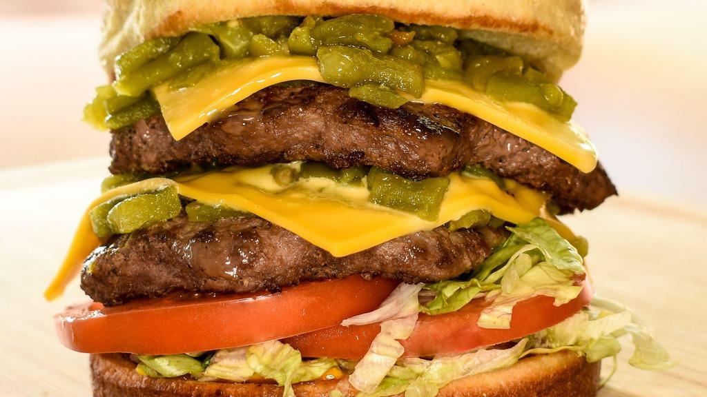 Renegade Burger · Grilled bun, 2 X chopped green chile, 2 X cheese, lettuce, tomato, pickles, mustard and ketchup. Made with two Angus beef patties. 1300 Cal.