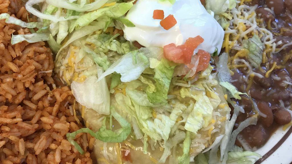 Chimi Platter · Crispy fried burrito, choice of meat and chile, topped with topped with cheddar-jack cheese, lettuce, and tomato and sour cream. Served with rice and beans. 760-1130 calories.
