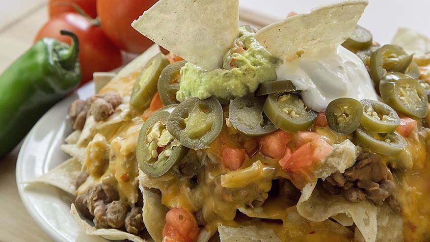 Nacho Supreme · Tostada chips, slow-cooked beans, queso sauce, jalapenos, guacamole, sour cream, and tomato. 1380 calories.