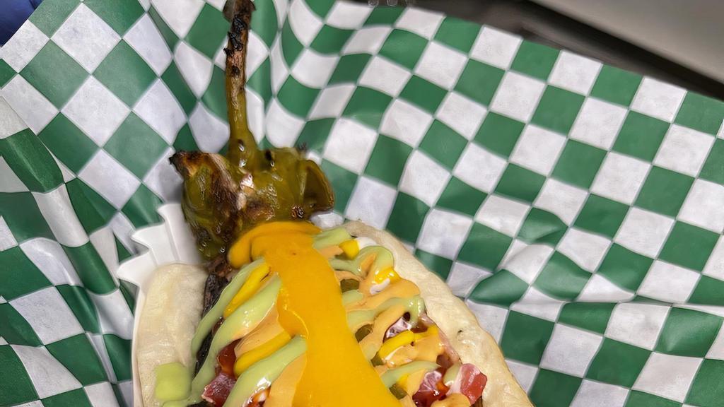 Anaheim Chile Dog · Hot dog wrapped in a non-spicy anaheim green chile, stuffed with mozzarella cheese. / Hot dog envuelto en un chile verde anaheim no picante, relleno de queso mozzarella.