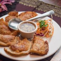Pot Stickers (6 Pcs) · Pan-fried pot stickers filled with chicken and served with our house zesty ginger vinaigrett...