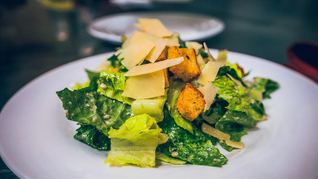 Caesar Salad · Chopped romaine lettuce, parmigiano cheese & caesar dressing.