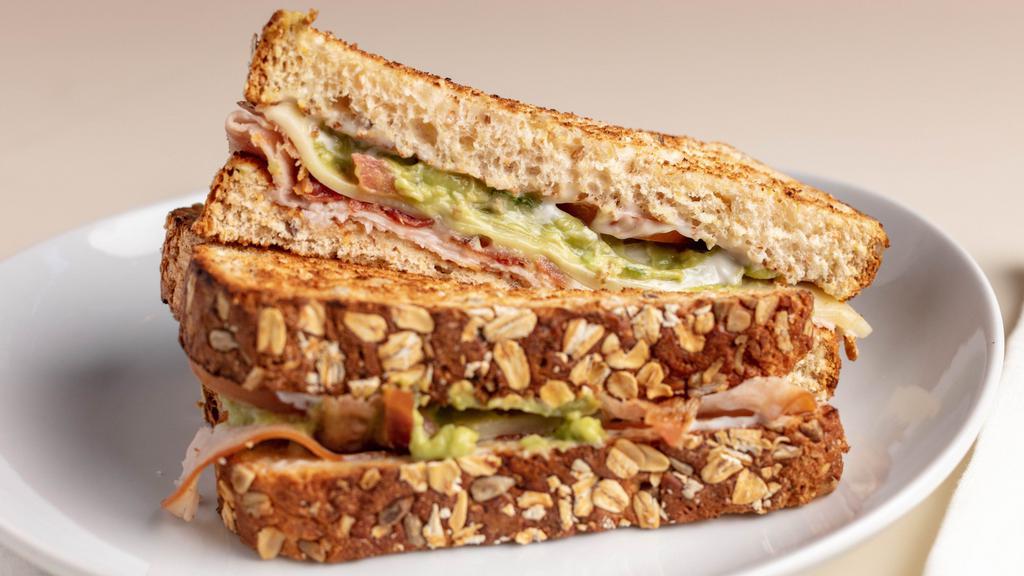 Turkey Bacon Avocado Sandwich · Turkey &  bacon with sliced avocado and cheddar cheese. Served with a side salad or chips