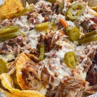 Bbq Nachos · White queso, baked beans, coleslaw, BBQ sauce, jalapeños, and your choice of meat.