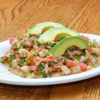 Ceviche Tostada · White fish, onions, tomatoes, cilantro, and jalapenos marinated in lime juice on a crispy co...