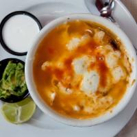 Sopa De Tortilla A La Suiza · Corn tortilla soup with a blend of melted cheese on top fried corn tortilla strips in a Mexi...