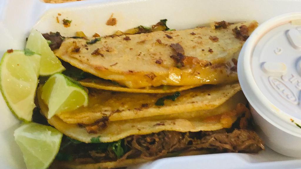 Birria Taco · Double 6 inch corn tortillas with cheese melted onto tortilla with shredded beef and cilantro and onions. Served with consume.