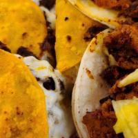 Birria Nachos · Cheese smothered nachos with beef stew, pico de gallo, sour cream and jalapeños.
