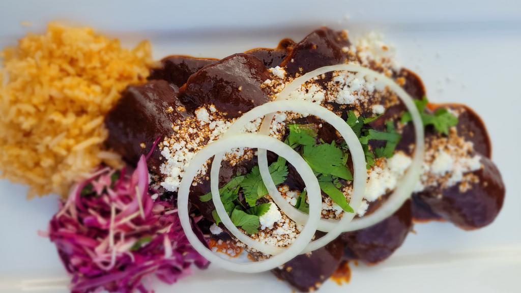 Cheese Enchiladas · Three enchiladas filled with Oaxacan cheese. Topped with Oaxacan mole sauce, queso fresco, onions, and cilantro. Served with rice and salad.