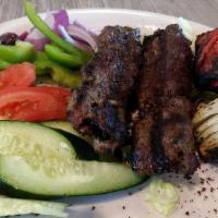 Lulu Kebab Plate (Iraqi Style) · Prime ground beef mixed with onion and spices grilled with onions and tomato served with hum...