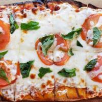 Classic Margherita Flatbread · Fresh tomatoes and basil on red sauce with mozzarella and drizzled with extra virgin olive o...