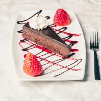 Flourless Chocolate Torte · Rich, dense slice of chocolate torte drizzled with raspberry coulee. Gluten free.