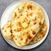Butter Lovin' Naan · Freshly baked bread in a clay oven garnished with butter