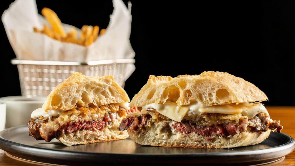 Stk Sandwich* · Shaved coffee-rubbed ribeye steak topped with caramelized onions, Gruyere cheese & horseradish cream. Served with french fries.
