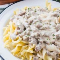 Ground Beef Stroganoff  · Ground beef smothered in mushroom cream sauce served over egg noodles. Comes with bread. Tax...