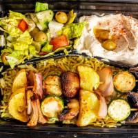 Veggie Skewer Bowl (Vegan) · Two grilled skewers of a mix of seasonal veggies with seasoned rice, Mediterranean Salad, an...