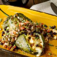 Chiles Rellenos · Stuffed Pepper with Cheese Topped with a Home-Made Tomato Sauce, onions and cilantro, served...