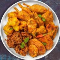 Pakora Podium · Assorted vegetables dipped in a light batter and fried until golden brown.