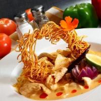 Khao Soi · Traditional northern Thai curry noodle soup served with chicken breast, fried onions, lime, ...