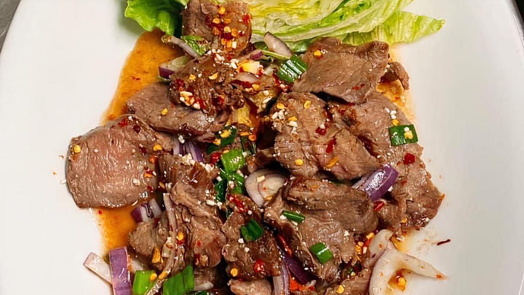 Flank Steak Waterfall · Isanneau nam tok, sliced grilled tender beef mixed with, onions, rice powder, chili, mint leaf, lime juice, Thai chili powder. Served with lettuce and sticky rice.