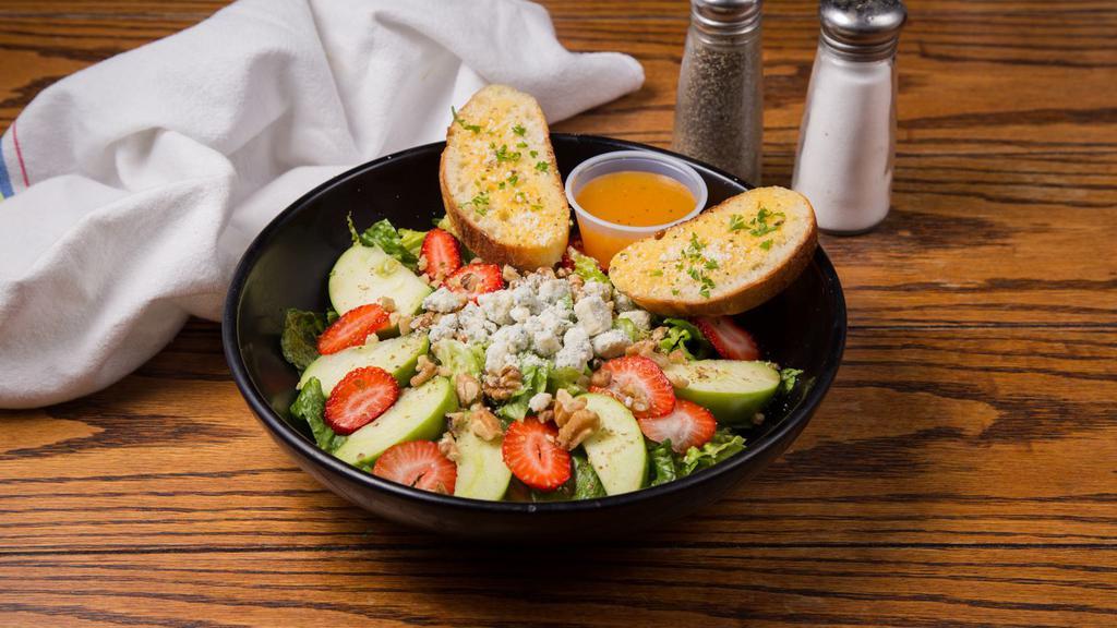 Apple Walnut Salad · Romaine, granny smith apples, strawberries, candied walnuts, bleu cheese crumbles tossed with mango citrus vinaigrette and garlic flatbread.