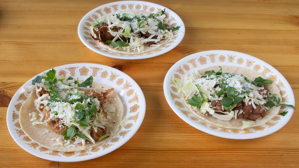 Taco · Choose from our shredded natural meat options of chicken, beef, pork, or our vegetarian options of pinto bean or house soy-rizo. All is topped with cabbage, cilantro, and cotija cheese with a radish and lime. Served on hand-pressed corn tortillas.