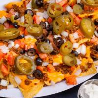 Nachos · A heaping serving of chips, seasoned beef, cheese sauce jalapeño, tomatoes, black olives and...
