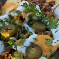 Cheese Steak Over Nachos · Steak Philly grilled with onion, bell peppers and mushrooms served on top of Nachos and chee...