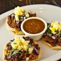 Al Pastor Tacos · Marinated, spit–grilled pork on corn tortillas with diced red onions, cilantro and pineapple...