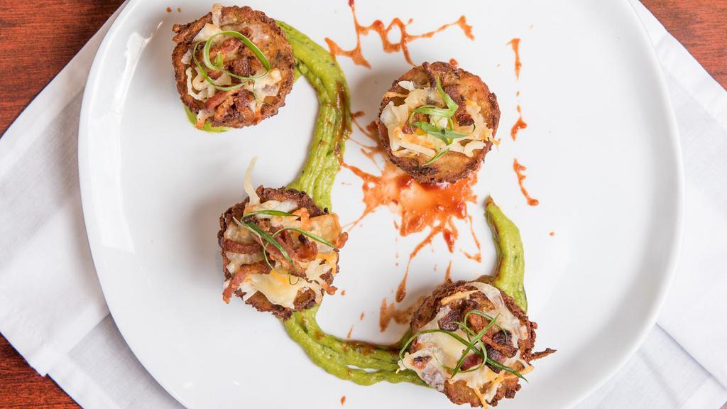 Jumbo Stuffed Tater Tots · Shredded potato, 3 blend smoked Cheddar cheese, mascarpone, chive, onion, with spicy ketchup splatter and green onion avocado coulis.