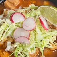 Pozole Rojo · Brothy soup made with pork, hominy and a mix of non-spicy red chiles. Topped with shredded l...