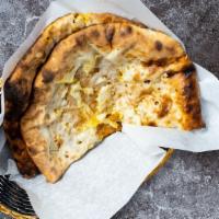 Fire Naan · Leavened flatbread made from white flour, cooked until puffy and blistering, then coated in ...
