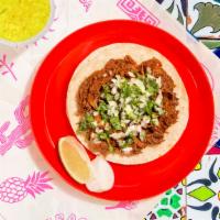 Barbacoa Taco · Braised lamb topped with cilantro and chopped onion on a soft corn tortilla.