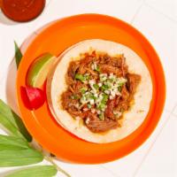 Chicken Carnitas Taco · Spicy marinated chicken and carnitas topped with cilantro and chopped onion on a soft corn t...