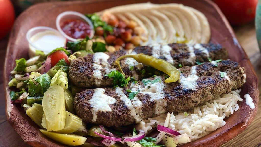 Kafta Kabab Over Rice Plate · Ground beef with chopped onion and parsley seasoned with a blend of spices, rice, mix salad, tzatziki, hummus and choice of sauce.