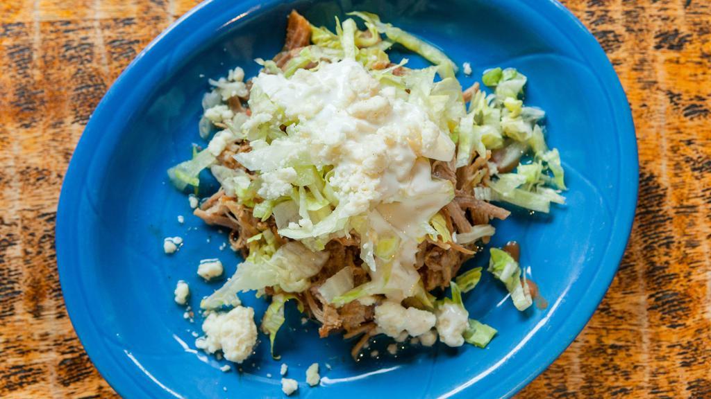 Sopes · 2 corn mill tortillas topped with refried beans, choice of meat , lettuce, queso fresco & sour cream