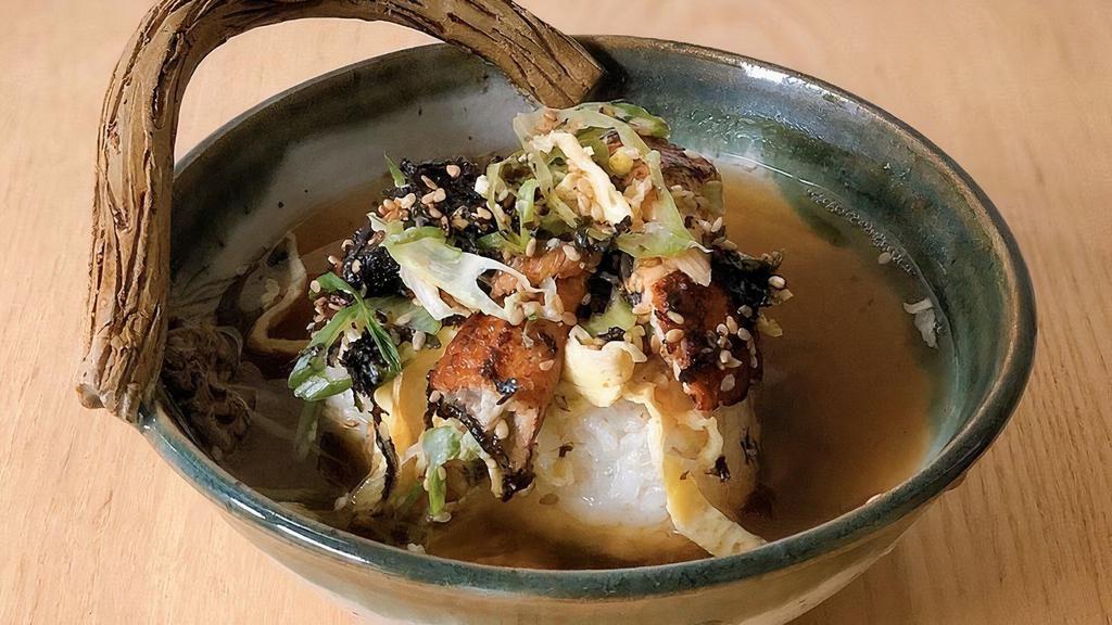 Unagi Yaki Onigiri Chazuke · Grilled rice ball in light dashi broth topped with grilled eel, seaweed, and wasabi.