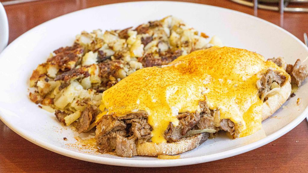 Shaved Ribeye Benedict · Toasted English muffin, topped with shaved ribeye, sautéed onions, melted pepper jack, poached eggs, and hollandaise sauce.