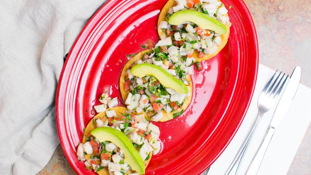 Tostadas De Ceviche (3) · Ground white fish marinated in lime juice, diced tomatoes, avocado, onion, cilantro and jalapenos. 
Served on flat crispy corn tortillas.