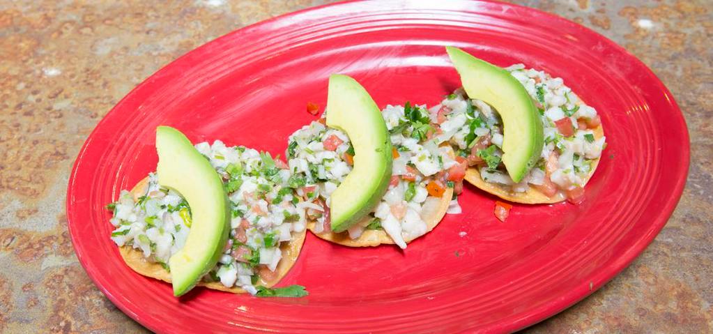 Tostadas De Ceviche (3) · Ground white fish marinated in lime juice, diced tomatoes, avocado, onions, cilantro and jalapeños. Served on flat crispy corn tortillas.
