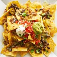 Loaded Nachos · Most loved. Tortilla chips, meat, beans, cheese, pico de gallo, sour cream, and guacamole.