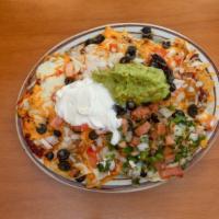 Nachos A La Gloria · Homemade chorizo, chile Verde, beans and chips, topped with melted cheese, pico de gallo, gu...